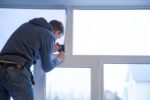 Homme qui pose le film sur une fenêtre